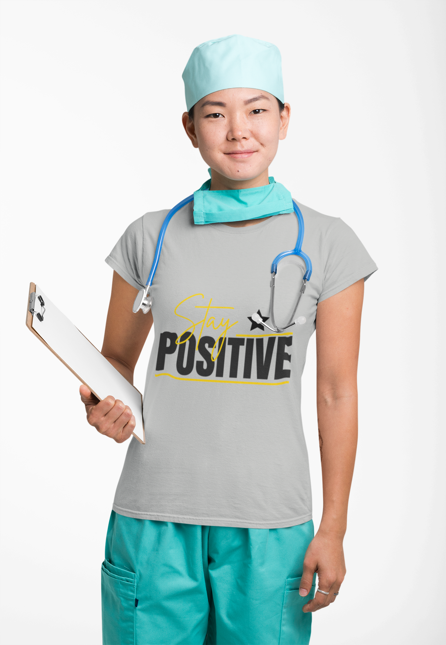 Person in medical scrubs with 'Stay Positive' shirt holding a clipboard on a white background