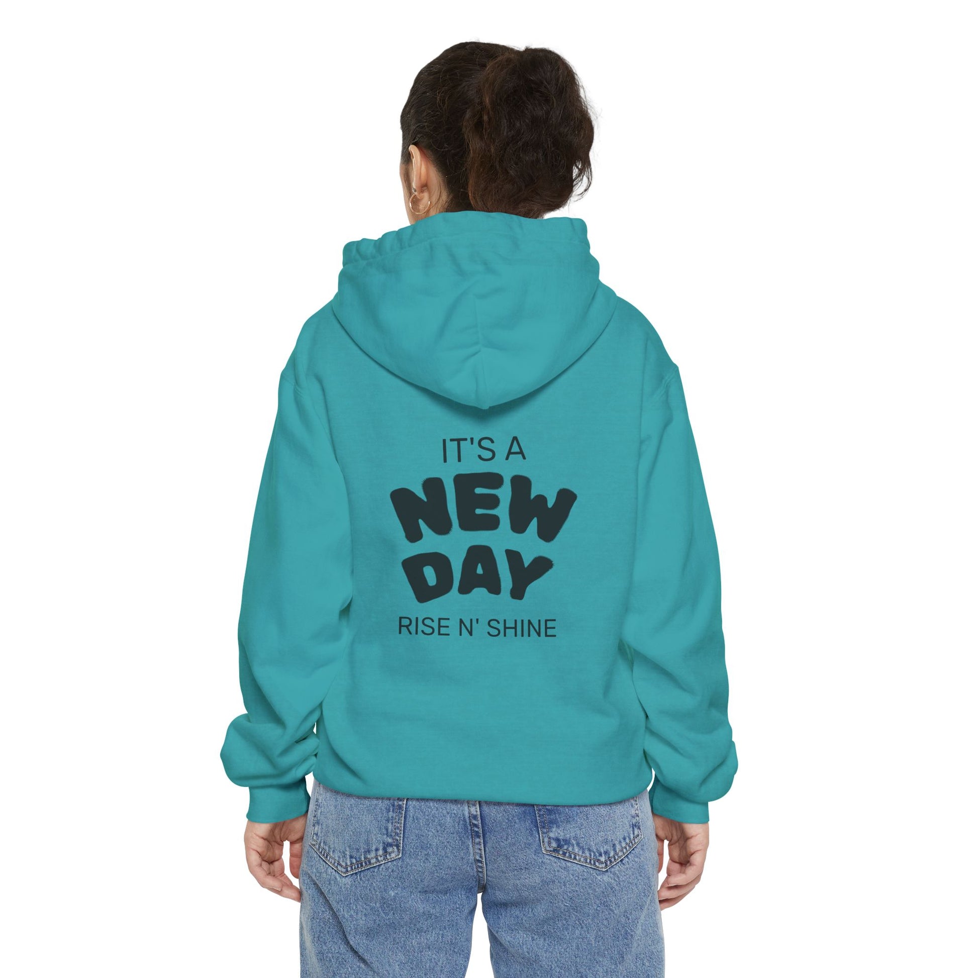 Person wearing a teal hoodie with 'It's a New Day Rise N' Shine' text on the back.