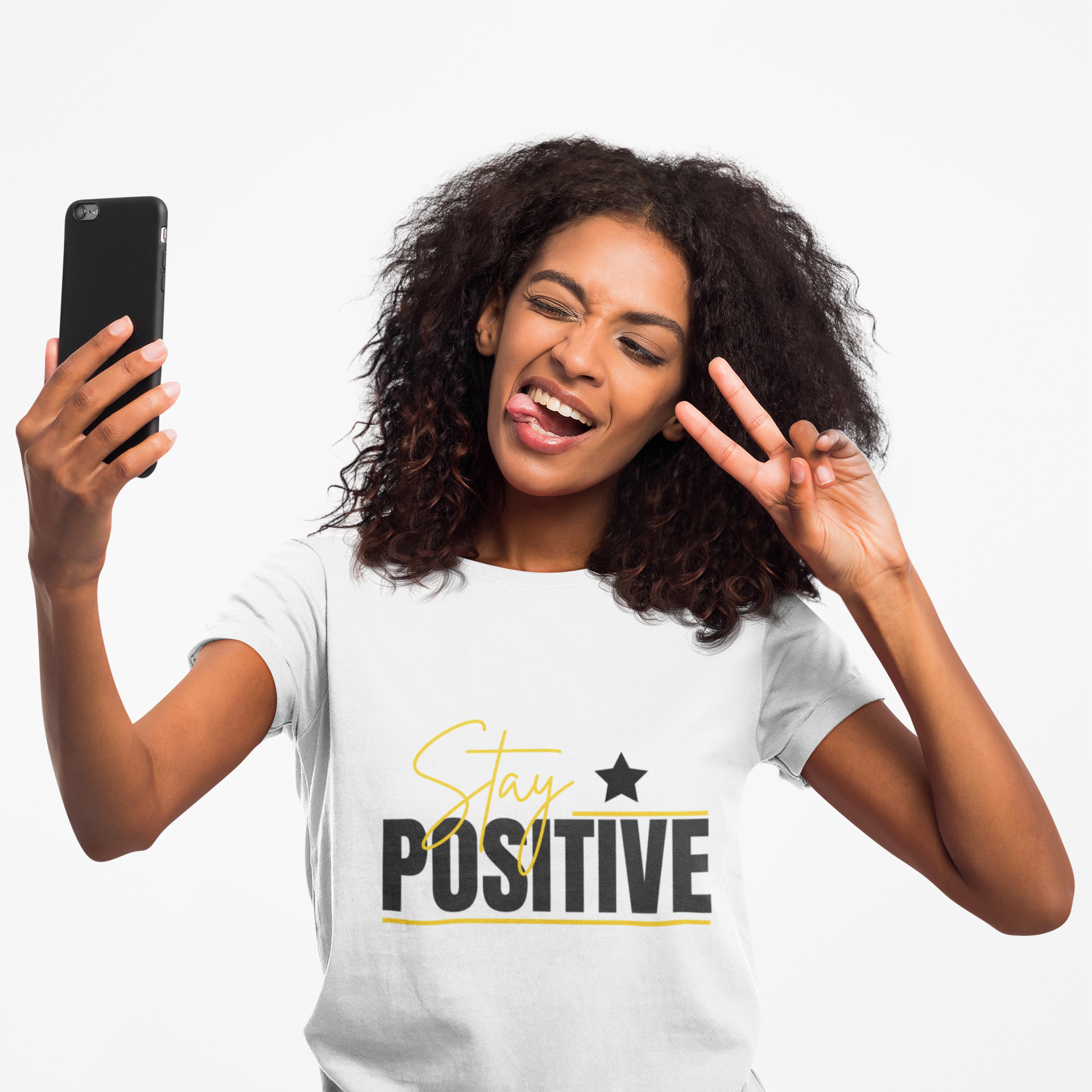 Woman wearing a 'Stay Positive' t-shirt, making a peace sign and looking at her phone.